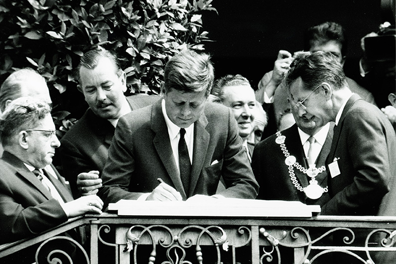 Schwarzweiß-Fotografie von US-Präsident John F. Kennedy auf der Treppe vor dem Alten Rathaus am Bonner Marktplatz