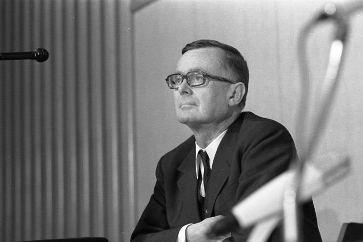 Bundeswirtschaftsminister Karl Schiller bei einer Pressekonferenz 1969 im Bundeshaus, am Podium sitzend und den Journalisten zuhörend