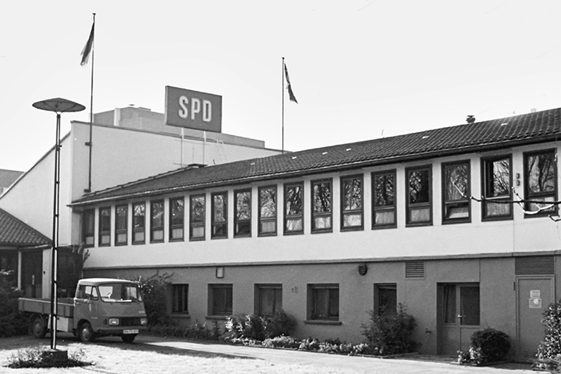 Black-and-white photography, view of a building in lightweight construction, on top of the roof the SPD logo.