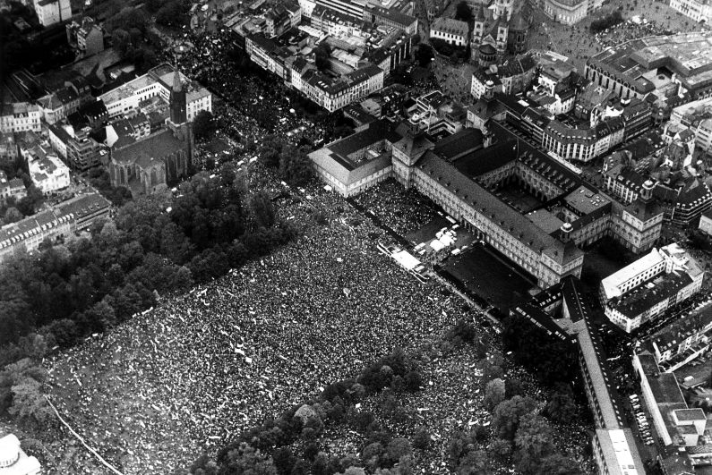 Schwarzweiß-Luftaufnahme, Blick auf den mit Friedensdemonstranten gefüllten Hofgarten und die Bonner Universität