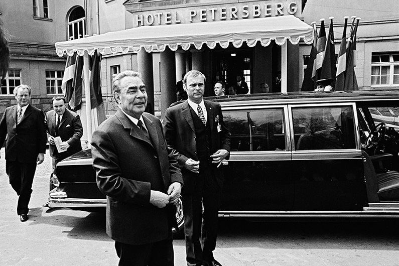 CPSU General Secretary Leonid Brezhnev in front of a black limousine, behind him the entrance of the Petersberg Hotel.