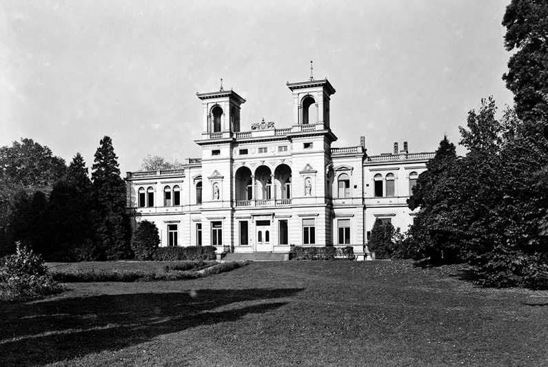 Black and white photography, white building, park in front.