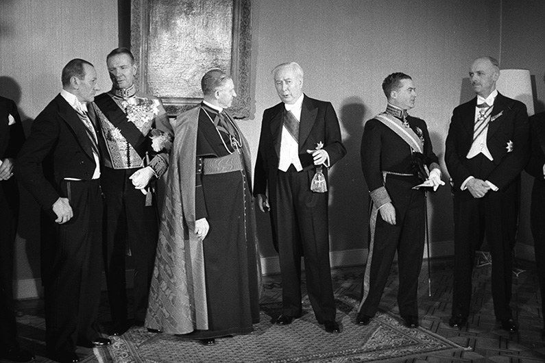 Black and white photography with festively dressed men in tail coats.